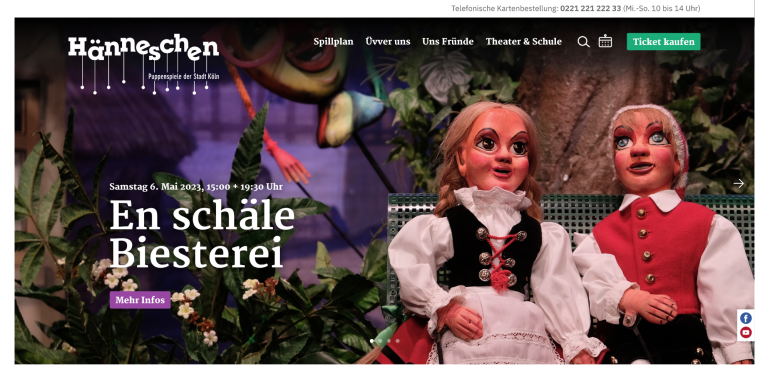 Puppen in traditioneller Kleidung vor einer bunten Kulisse mit Pflanzen und Dekoration.